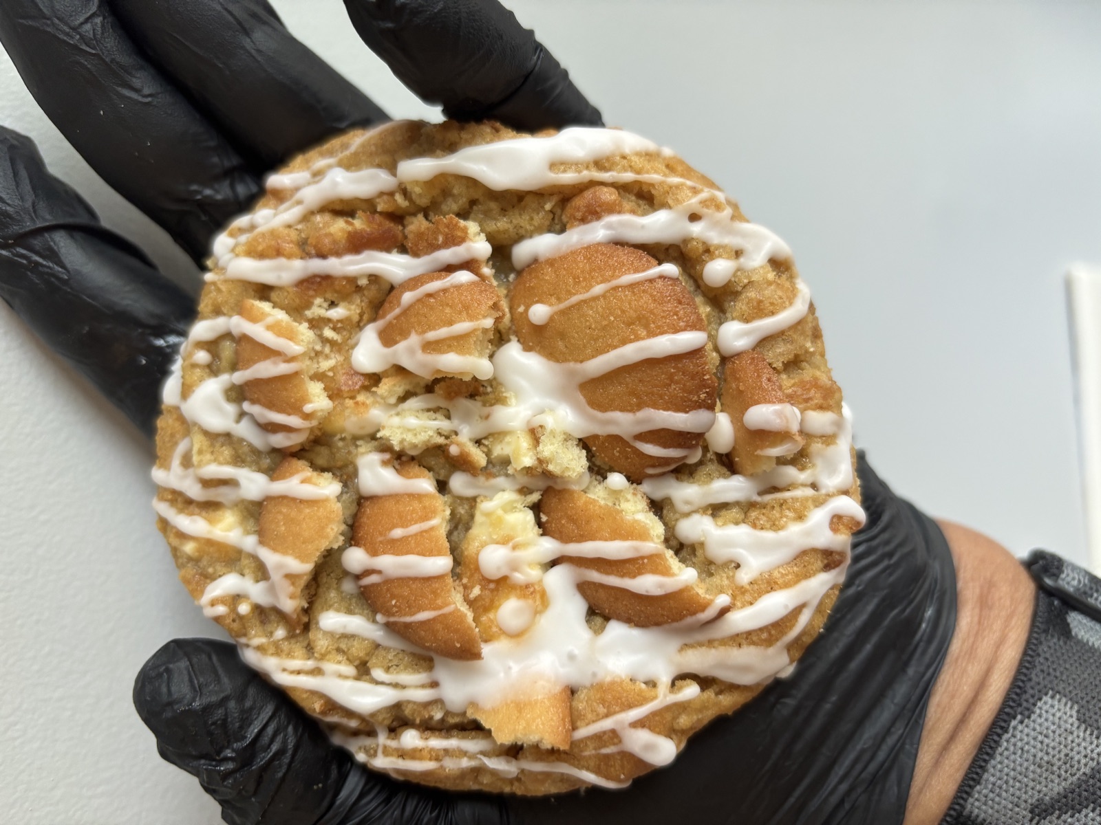 Banana pudding cookie topped with vanilla wafers and white chocolate drizzle