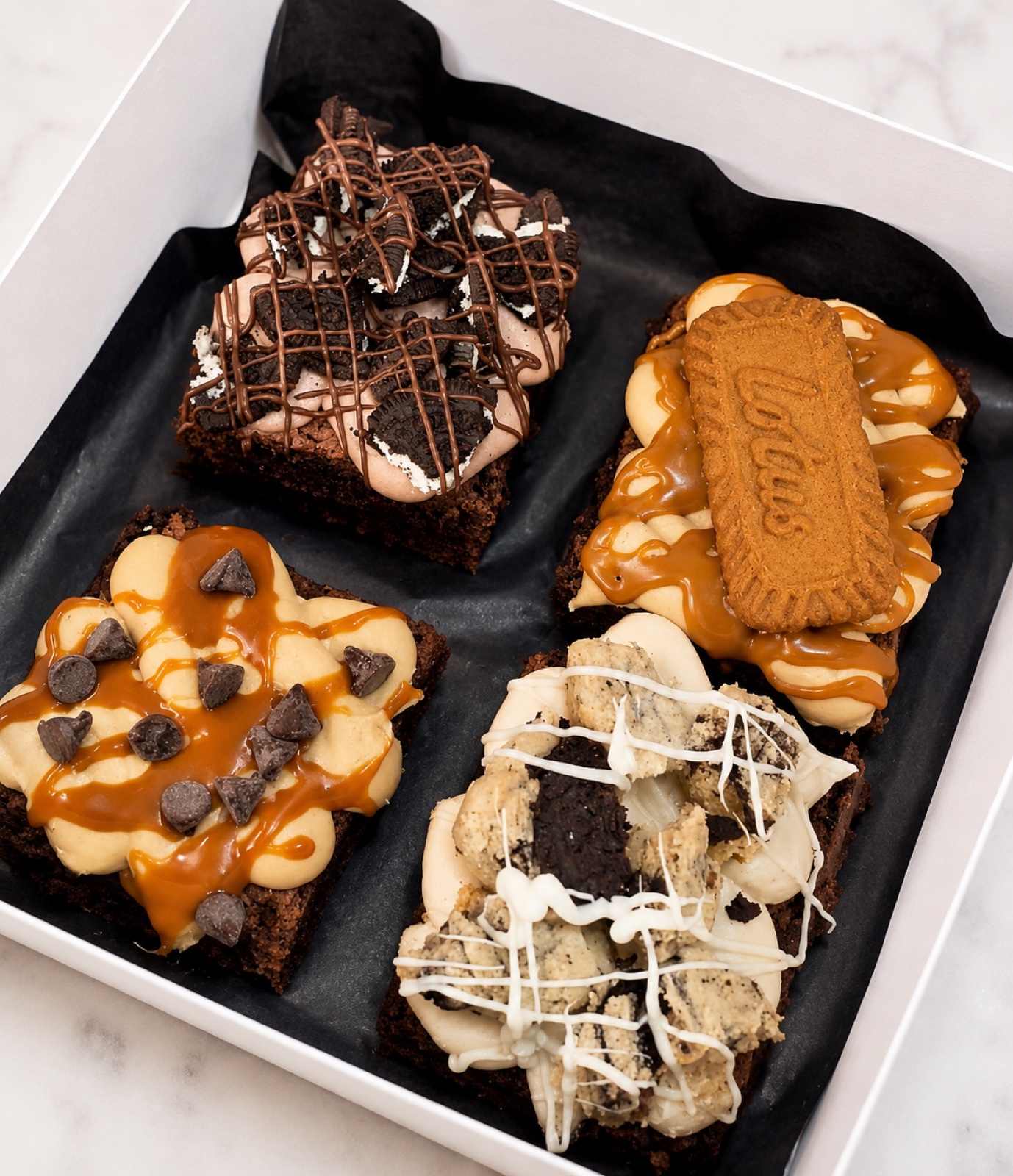 July brownie collection with four decorated brownie flavors in a gift box